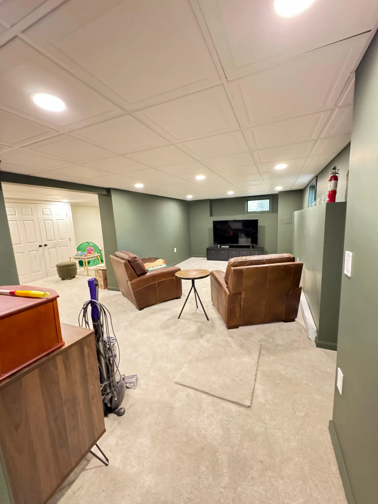 Finished basement family room with recliners and TV area by Regulus Construction
