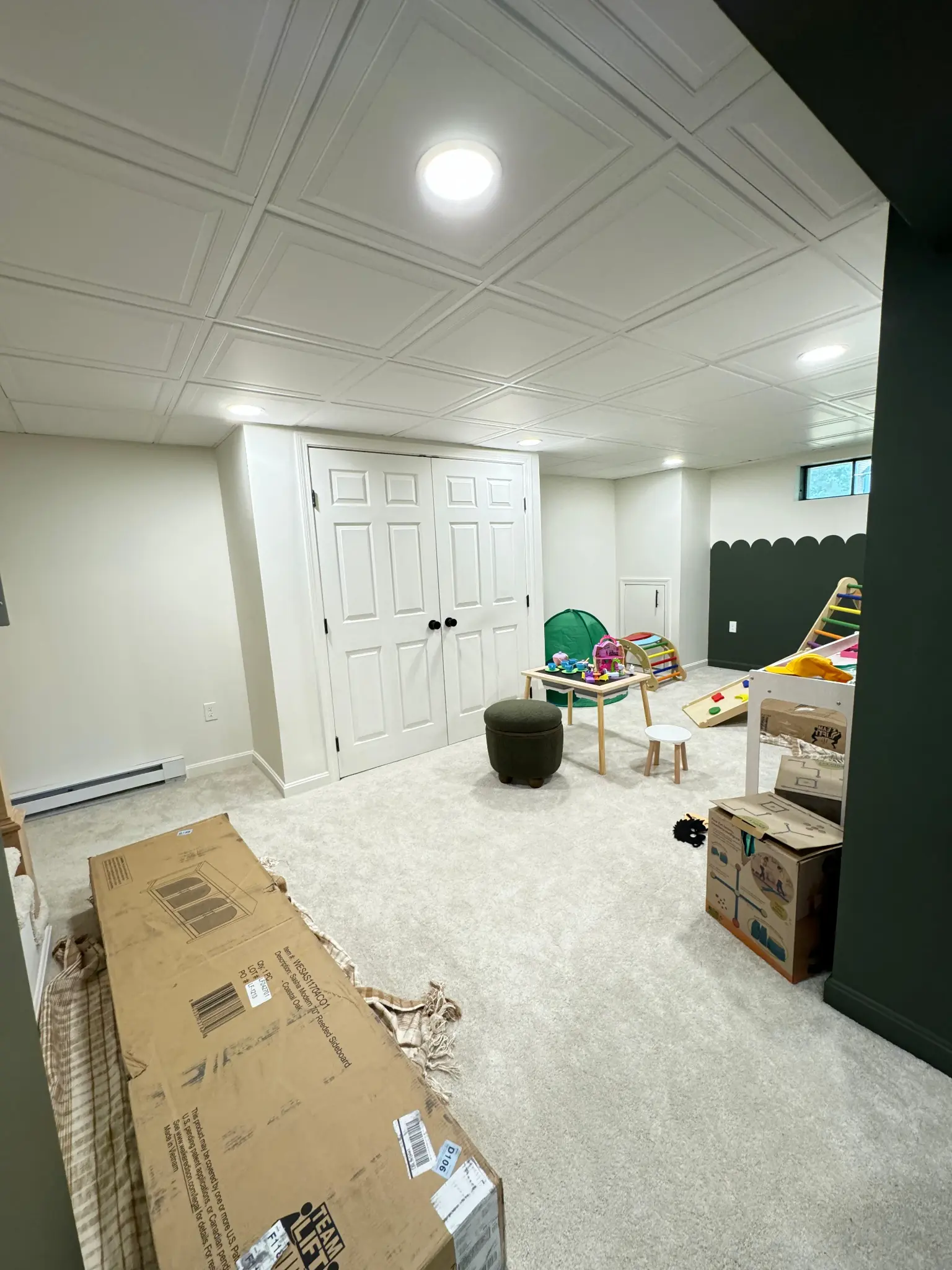 Finished basement playroom with drop ceiling and closet storage by Regulus Construction