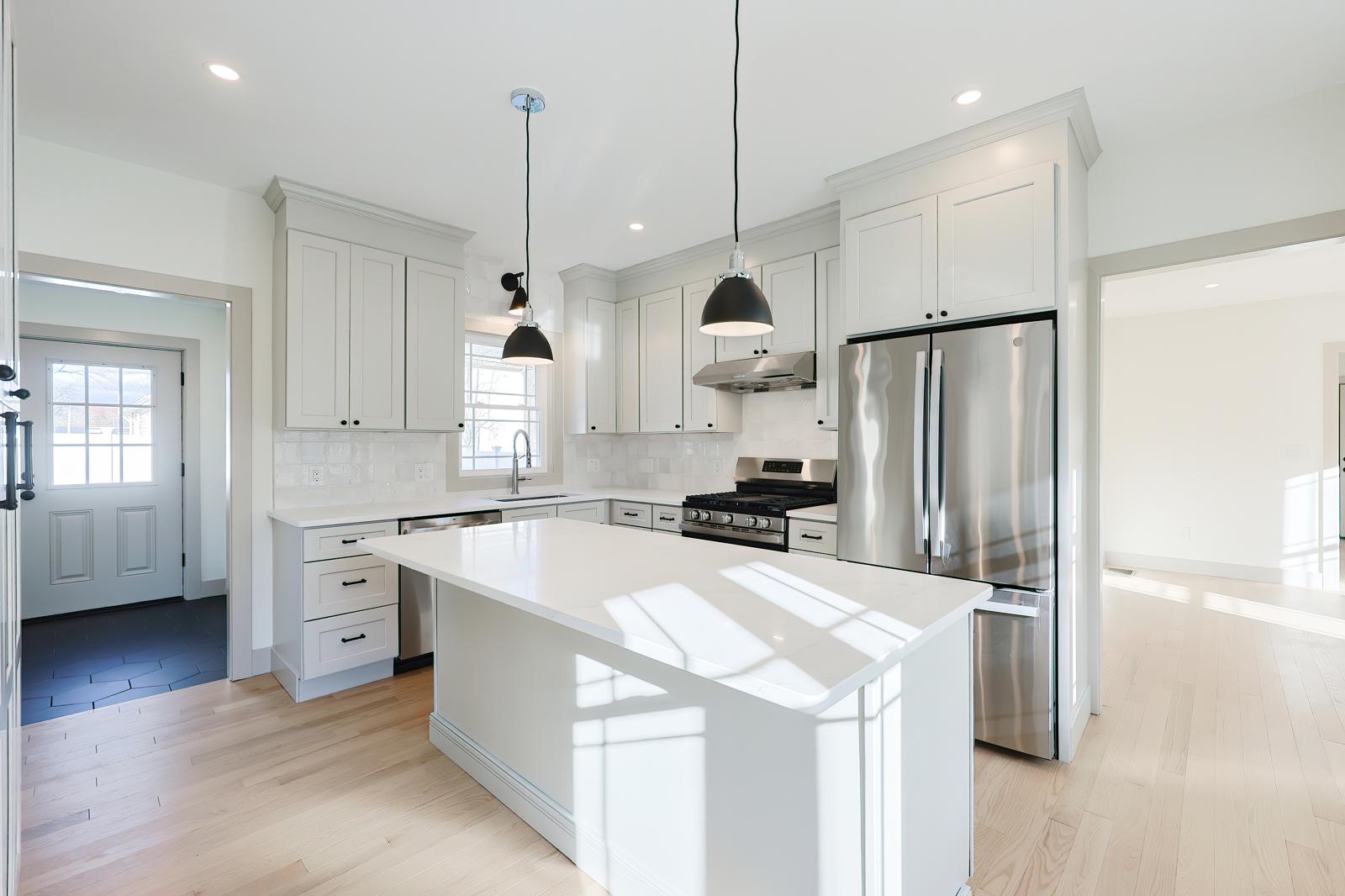 Kitchen remodel with gray cabinets and pendant lights in Massachusetts
